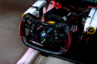 Close-up of a BMW steering wheel in a racing simulator setup