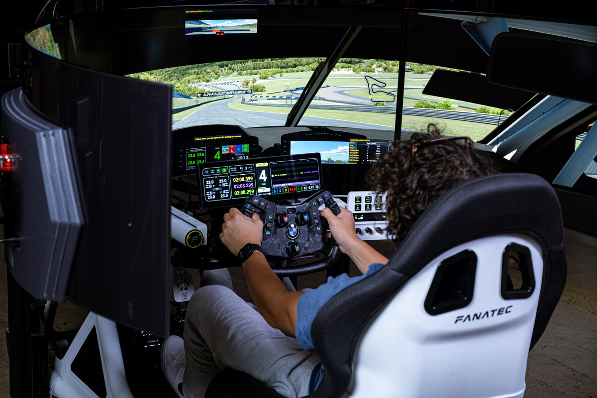 Driver mid-session in a complete TURNKEY racing simulator with triple displays